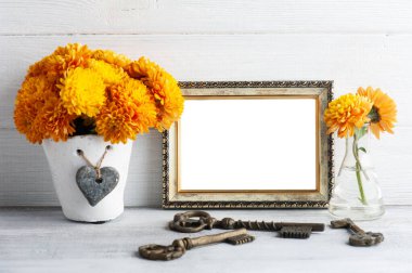 Boş fotoğraf çerçevesi ve beyaz kırsal arka planda turuncu kasımpatı çiçekleri