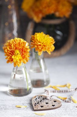 Kırsal masada sarı kasımpatı. Kalpli sonbahar dekoru