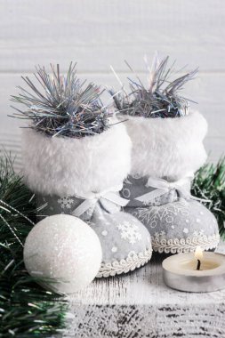 Oyuncak botlu, toplu ve yanan mumlu Noel beyazı süslemesi. Tebrik kartı 