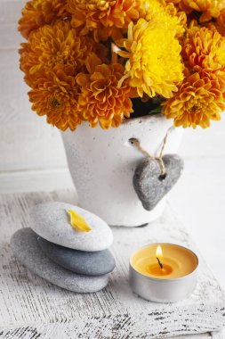 Turuncu kasımpatı çiçekleri çakıl taşları ve aroma mumu beyaz kırsal arka planda