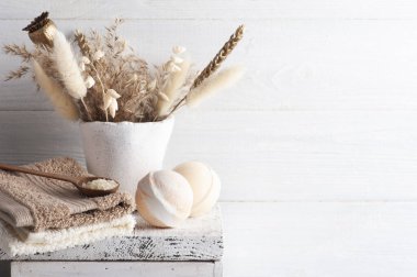 Banyo bombaları ve kırsal arka planda altın kuru çiçekler. Monokrom tarzında tuzlu spa düzenlemesi