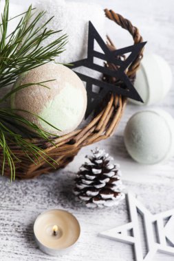 Noel SPA kompozisyonu içinde çam ağacı dalları ve yıldızlarla dolu sepetli bomba, yanan mum.