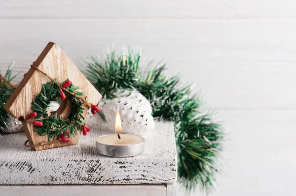 Dekoracja Świąteczna Zabawką Drewniany Dom Zapalona Świeca Białym Rustykalnym Tle — Zdjęcie stockowe