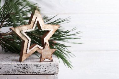 Ahşap yıldızlı Noel süslemesi ve kır arka planında çam ağacı. Karşılama için alanı kopyala