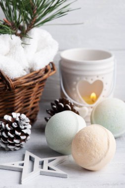 Noel SPA kompozisyonu içinde çam ağacı dalları ve yıldızlarla dolu sepetli bomba, yanan mum.