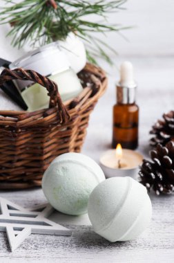 Noel SPA kompozisyonu içinde sepetteki güzellik ürünü. Çam ağacı dalları ve gerekli yağ, yanan mum.