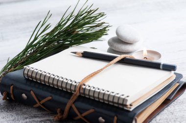 Boş bir defter, çam ağacı ve kır arka planda kuru çiçekler. Metnin için kopyalama alanı olan tebrik kartı