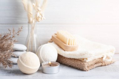 Banyo bombaları ve kuru çiçekli spa kompozisyonu tek renkli arka planda. Mum ve beyaz çakıl taşlı havlu. Bir kişi için sıcak taş masaj terapisi. Güzellik tedavisi ve rahatlama 