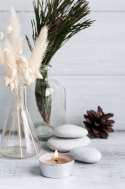 Noel SPA kompozisyonu, çam ağacı dalları ve yanan bir mum. Güzellik sağlığı, vücut bakımı. Anneler Günü, Noel ya da düğün için tebrik kartı