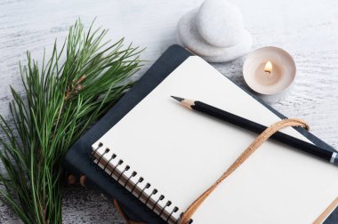 Boş bir defter, çam ağacı ve kır arka planda kuru çiçekler. Metnin için kopyalama alanı olan tebrik kartı