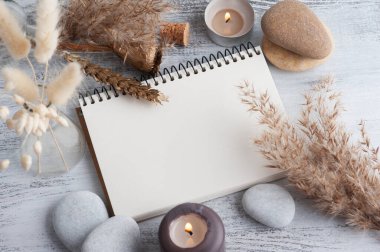 Boş bir defter ve kır arka planında kuru çiçekler. Metnin için kopyalama alanı olan tebrik kartı