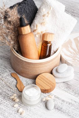 Kremalı kozmetik kavanoz, nemlendirici vücut losyonu ve ahşap arka planda gerekli yağ. Çevre dostu ambalajlı doğal organik spa