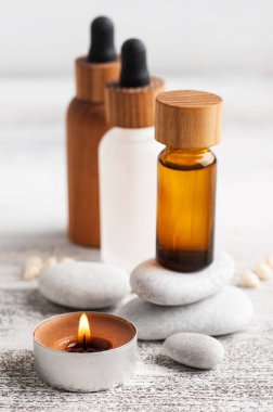 Ahşap arka planda yeniden kullanılabilir şişelerdeki temel yağ. Çevre dostu ambalajlı doğal organik spa