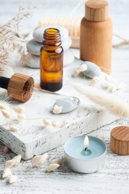 Ahşap arka planda yeniden kullanılabilir şişelerdeki temel yağ. Çevre dostu ambalajlı doğal organik spa 