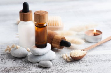 Ahşap arka planda yeniden kullanılabilir şişelerdeki temel yağ. Çevre dostu ambalajlı doğal organik spa