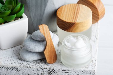 Kremalı kozmetik kavanoz, nemlendirici vücut losyonu ya da ahşap arka planda maske. Çevre dostu ambalajlı doğal organik spa