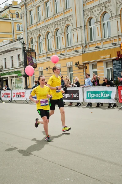 Pareja joven corre con globos — Foto de Stock