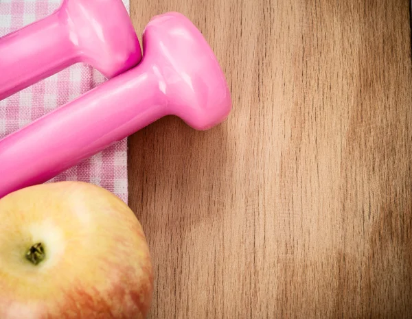 Manequins rosa e maçã na mesa de madeira — Fotografia de Stock