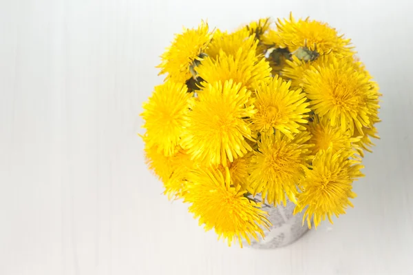 Dandelions in a basket on wooden background — Stock Photo, Image