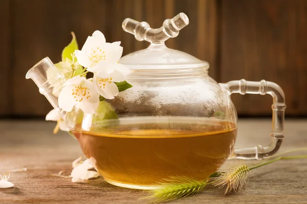 Jasmine tea in a glass tea pot on dark wooden background — Stock Photo, Image