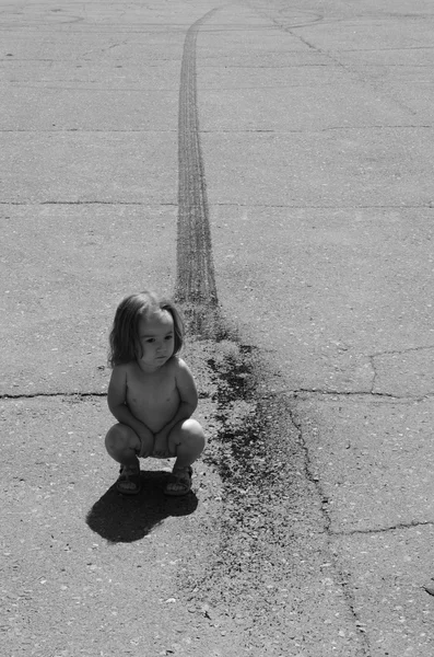 Menina em uma estrada de asfalto com marcas de derrapagem — Fotografia de Stock