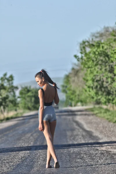 Hitchhiking model posing on motorway — Stock Photo, Image