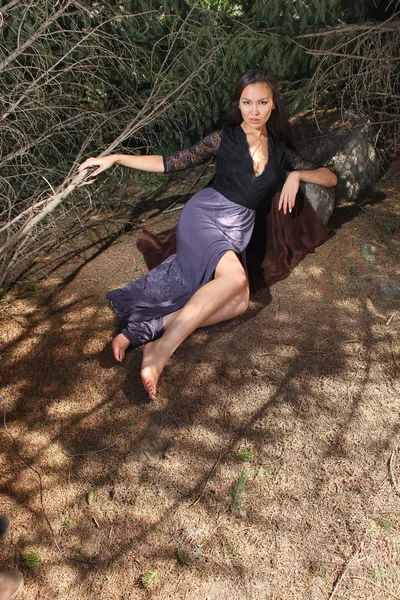 Elegant woman lying in spruce branches — Stock Photo, Image