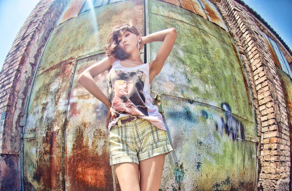 Girl on the background of an abandoned warehouse — Stock Photo, Image