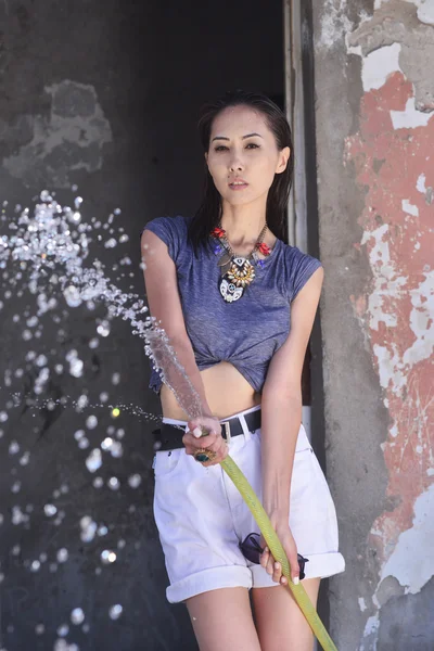 Fille avec de l'eau près de la vieille maison abandonnée — Photo