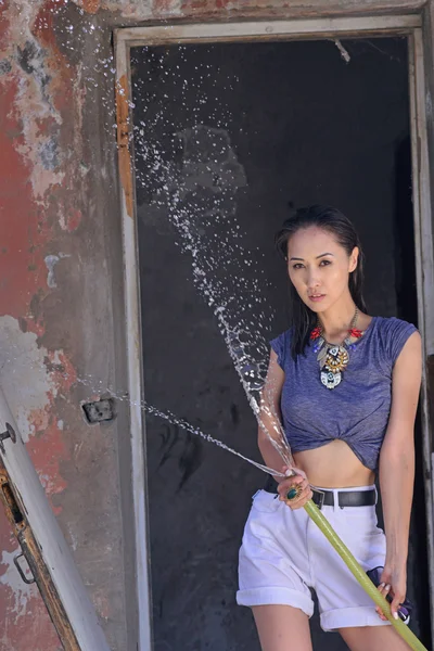 Girl with water near the old abandoned house — Stock Photo, Image