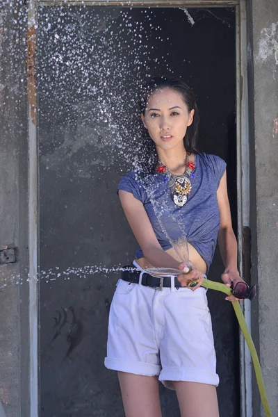 Fille avec de l'eau près de la vieille maison abandonnée — Photo