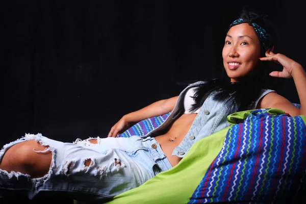 Girl posing in the style of rock lying on bean bag — Stock Photo, Image