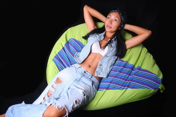 Girl posing in the style of rock lying on bean bag — Stock Photo, Image