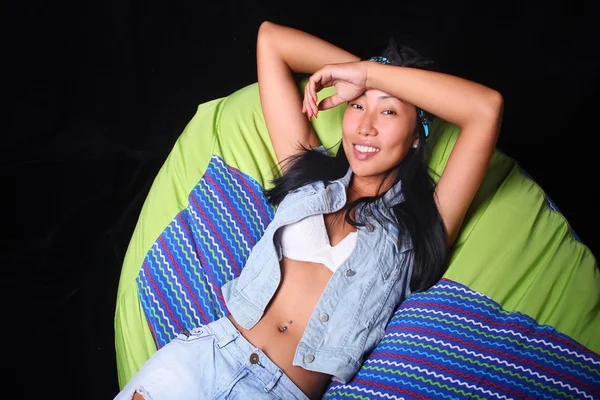 Girl posing in the style of rock lying on bean bag — Stock Photo, Image