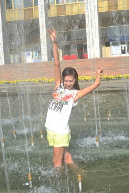 Şehir çeşme su jetleri altında dans neşeli kız 