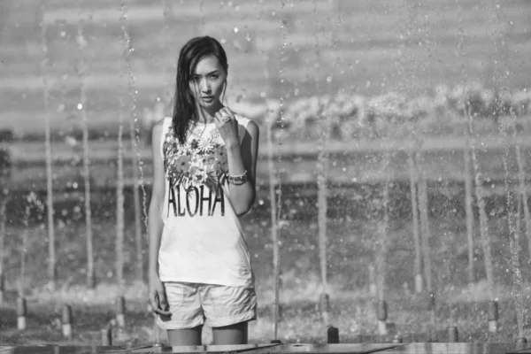 Chica alegre bailando bajo chorros de agua en la fuente de la ciudad —  Fotos de Stock