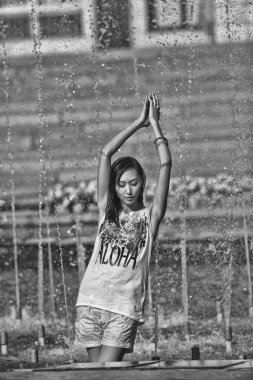 Şehir çeşme su jetleri altında dans neşeli kız 