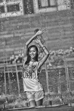 Şehir çeşme su jetleri altında dans neşeli kız 