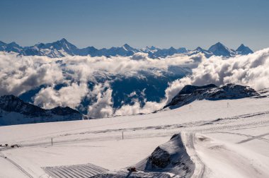 Güneşli bir günde mavi gökyüzü ve bulutlarla kaplı kar örtülü dağların kış manzarası. İsviçre 'deki ünlü Diablerets Buzulu. Doğada huzur ve güzellik.