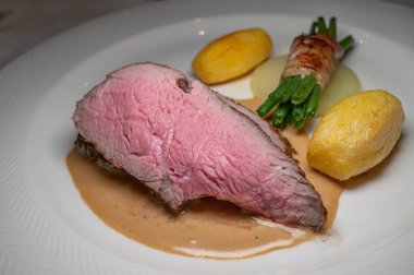 Soslu, beyaz tabakta sebzeli ızgara biftek. Lezzetli ve lezzetli..