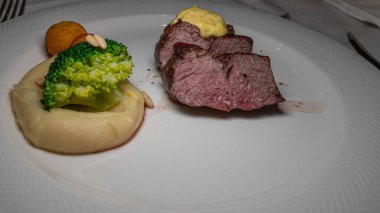 Beyaz tabakta sebzeli ızgara biftek. Lezzetli ve lezzetli..