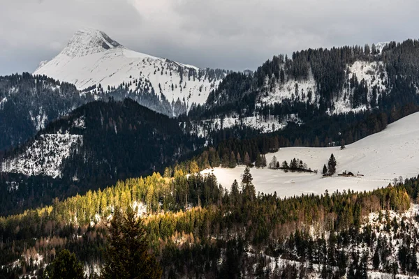 Montanhas cobertas de neve cercadas por nuvens no inverno. — Fotografia de Stock