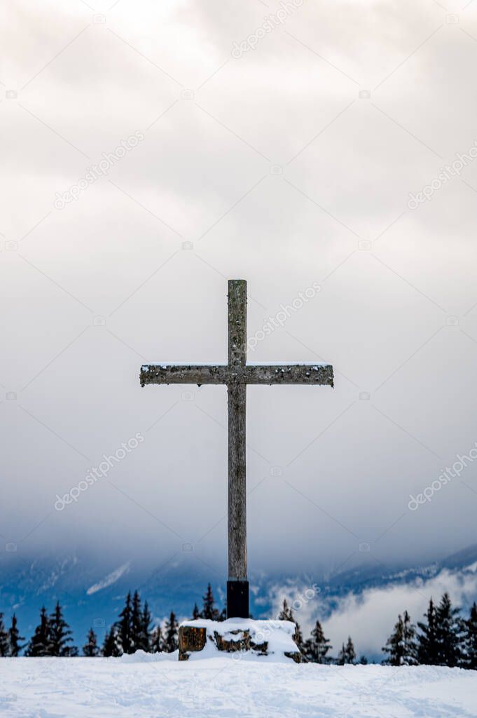 Cross in the snow. Wooden religious cross in winter. Les Pleiades, Switzerland. Tranquil scene.