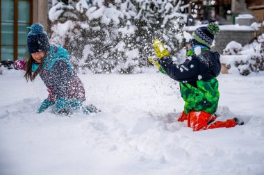 Çocuklar karla oynuyor. Kışın kar atan iki Asyalı çocuk. Mutlu çocukluk ve birliktelik. Zermatt, İsviçre.