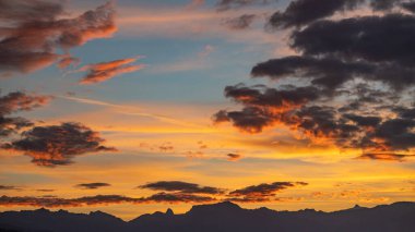 Dağların üzerinde gün batımı. Gün batımında kırmızı, sarı ve turuncu renklerle dramatik bir gökyüzü. Lozan, İsviçre. Doğada güzellik. Sakin sahne.