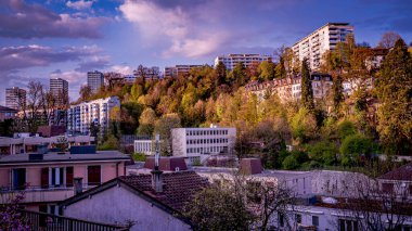 Ağaçlarla çevrili yüksek binaların ve evlerin panoramik manzarası. Lozan, İsviçre. Şehir manzarası.