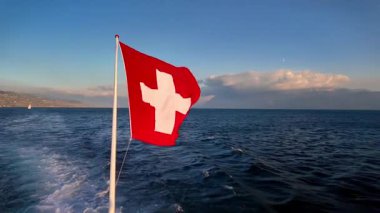 İsviçre Ulusal Bayrağının İsviçre Sunset, İsviçre 'de Cenevre Gölü' nde Dalgalanışı.