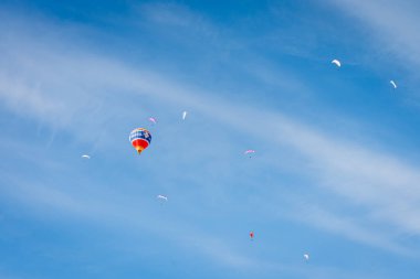 Şato d 'oex, Vaud Canton, İsviçre - 1 Şubat 2026: Sıcak Hava Balonu ve Paragliderler İsviçre' de Kış Festivali sırasında gökyüzünde uçuyor.