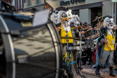 Basel, İsviçre - 25 Mart 2026: İsviçre 'de düzenlenen Basel Fasnacht 2026 sokak geçit töreni sırasında davul ve pirinç enstrüman çalan maskeli karnaval müzisyenleri.