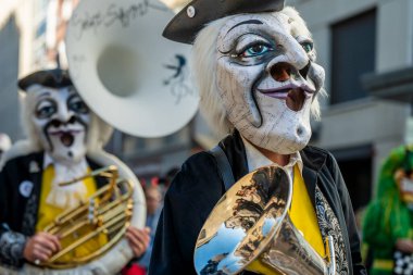 Basel, İsviçre - 25 Mart 2026: İsviçre 'deki Basel Fasnacht 2026 sokak geçit töreni sırasında pirinç enstrüman çalan maskeli karnaval müzisyenleri.